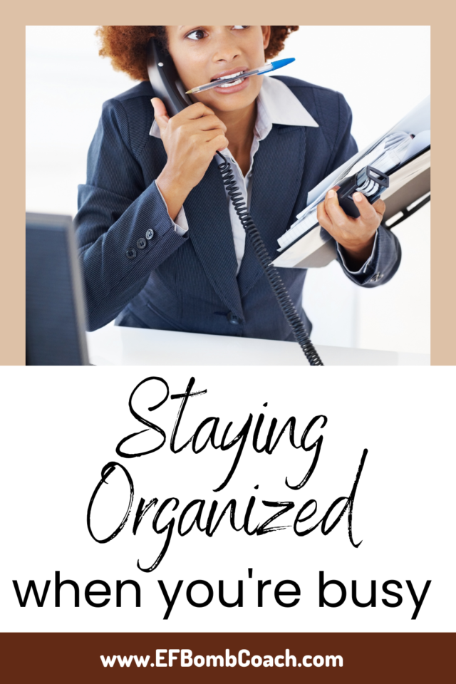 Staying organized when you're busy - woman with a stack of papers, on the phone, looking worried