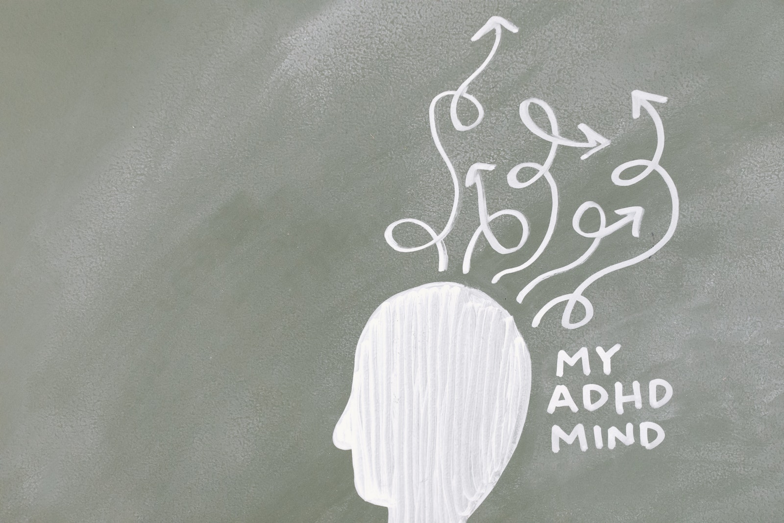 ADHD and women - chalkboard silhouette of a head with arrows pointing all over