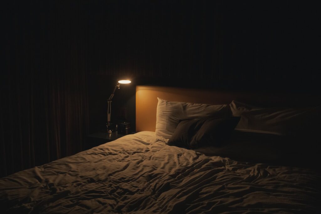table lamp turned-on near bed