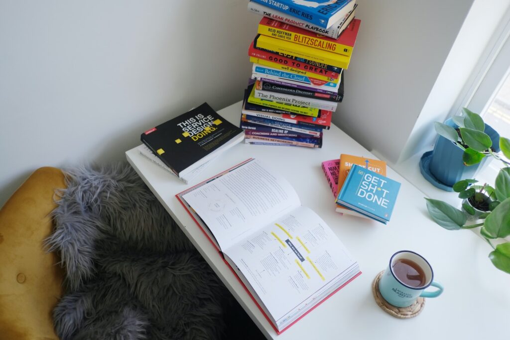 stack of books open notebooks coffee on white table