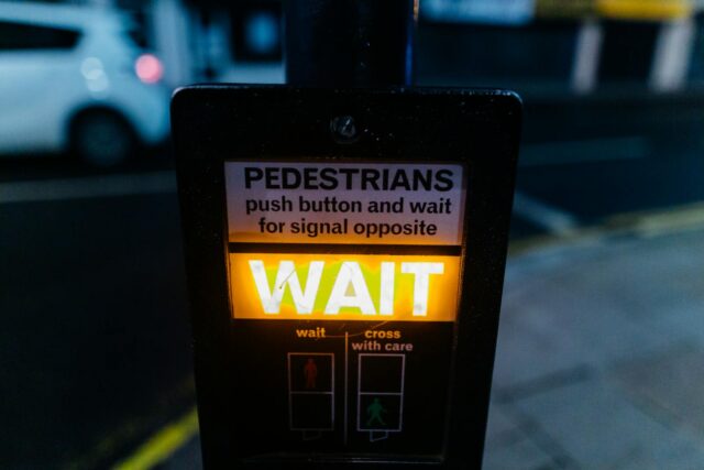 Close-up of an illuminated pedestrian crossing signal on a city street at night.
